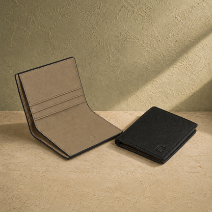 Two wallets, one beige and one black, on a textured surface with a neutral background.
