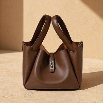 Zaya Amber brown leather handbag on a beige background, Alghaf