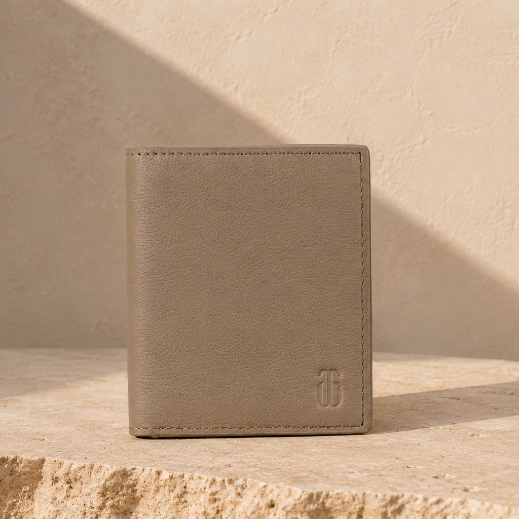 Beige leather wallet on a light stone surface with a neutral background